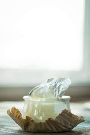 Jar with fresh yogurt on a rustic wooden table