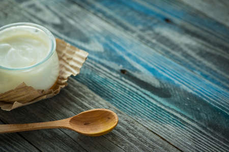 Jar with fresh yogurt on a rustic wooden tableの写真素材
