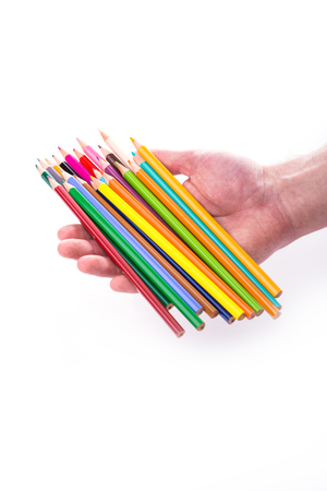 Bunch of color pencils in hands over white backgroundの写真素材
