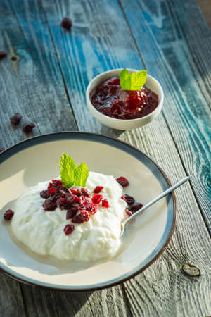 Plate with fresh yogurt on rustic wooden tableの写真素材