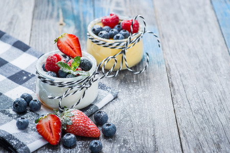 Fresh and healthy natural yogurt with berries on a rustic wooden tableの写真素材