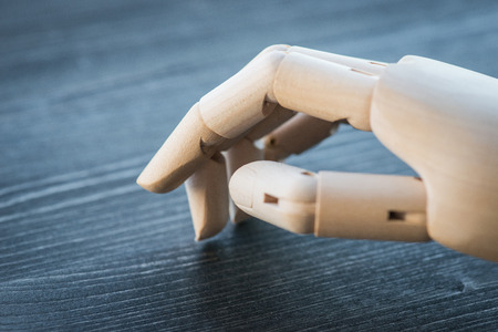 Artificial wooden hand on a rustic wooden tableの写真素材
