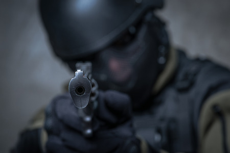 Terrorist soldier in helmet with big gun in hands