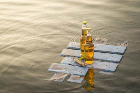 Beer bottles floating on the rustic wooden boardの写真素材