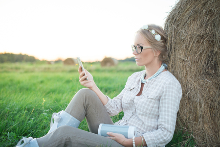 Beautiful young woman listening to the music in the fieldの写真素材