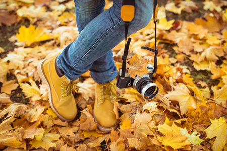 Warm yellow boots. Walking in yellow autumn leavesの写真素材