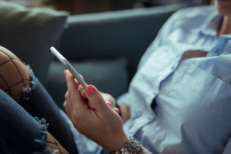 Beautiful young woman listening to the music on cozy sofaの写真素材