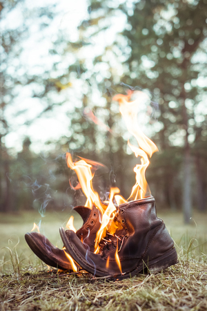 Burning shoes. Abstract composition of old shoes on fireの写真素材
