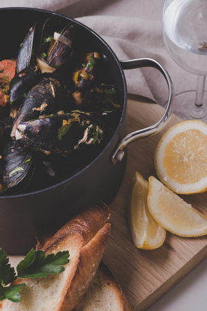 Freshly cooked sea mussels in deep black casseroleの写真素材