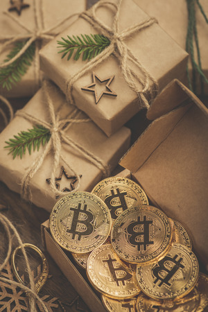 Christmas. Gifts. Bitcoins in a vintage style gift box on a rustic wooden tableの写真素材