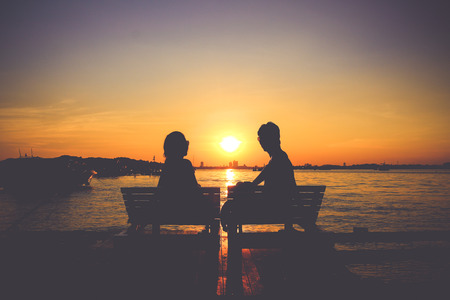 Silhouette of male and female at sunset backgroundの写真素材