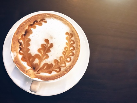 A cup of coffee on wooden table background, top viewの写真素材