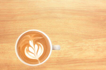 Closed up latte coffee with beautiful top up on wood backgroundの写真素材