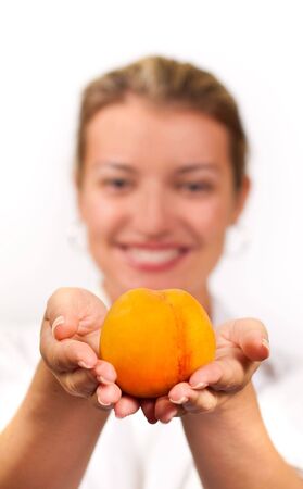 Smiling girl with tasty peach in her handsの写真素材