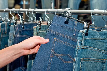 Man in the wear store choosing  blue jeansの写真素材