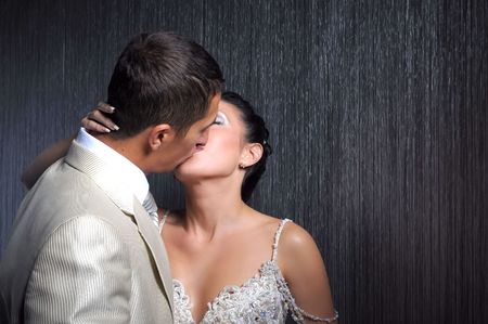 Bride and groom is kissing in the dark roomの写真素材