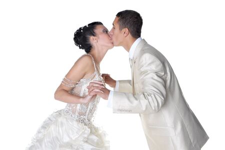 Isolated on white groom is kissing his bride wearing in wedding dressの写真素材