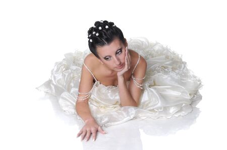 Beautiful young bride wearing in the wedding dress is dreamingの写真素材