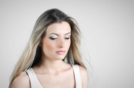 Beautiful sad young girl on the grey backgroundの写真素材