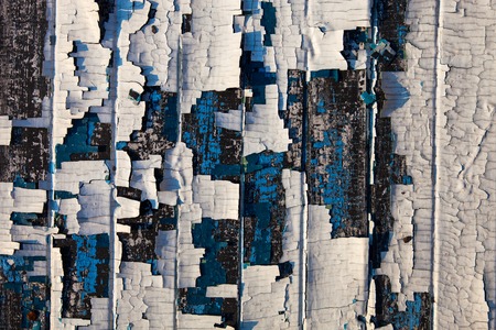 Old wooden planks with the remains of cracked white and blue oil-paintの写真素材