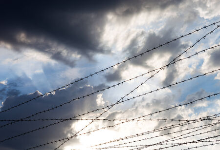 Barbed wire against the cloudy sky background.の写真素材