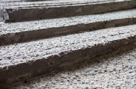 Grey concrete stairs with rough textured surface.