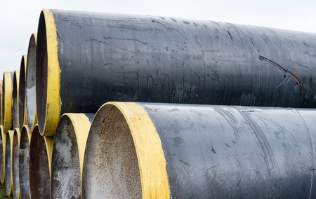 Stack of new metal pipes with yellow-painted edges.の写真素材