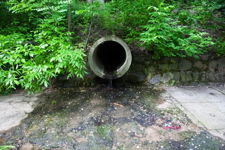 The concrete circular run-off pipe discharging waterの写真素材