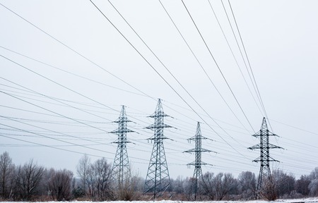 System of electricity pylons and power lines out-of-town in the winter day.