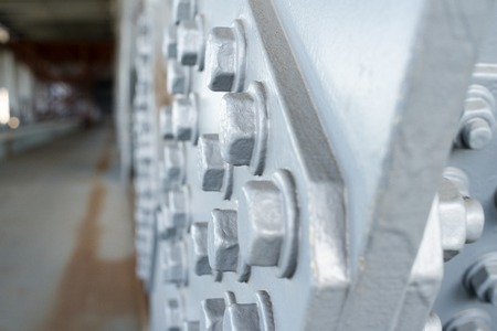 Gray painted hexagonal bolt heads on the metal surface. Close up.の写真素材