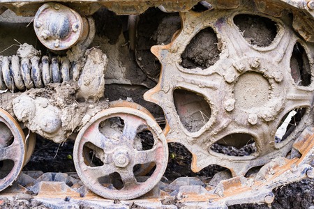 Road and drive wheels of the continuous (caterpillar) tracks with mud. Close up.の写真素材