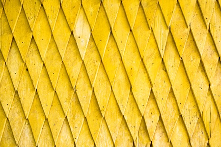 Yellow painted wooden shingle surface with rich texture.の写真素材