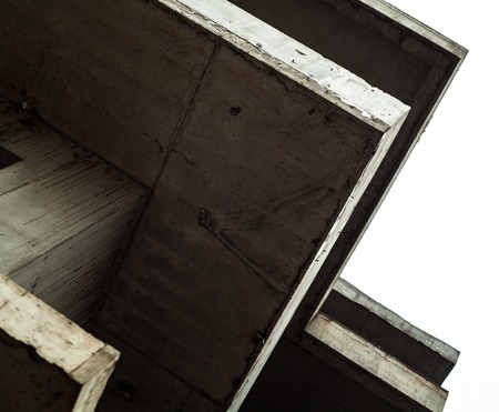 Concrete surfaces of the unfinished building against the white skyの写真素材