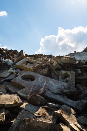 Heap of the damaged concrete blocks. Construction debris. Blue sky background,