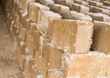 Raw bricks covered with sawdust drying in the open air.の写真素材