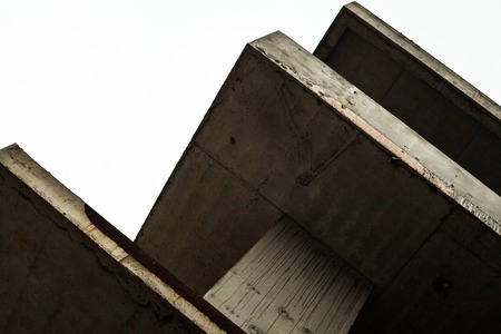 Concrete surfaces of the unfinished building against the white skyの写真素材