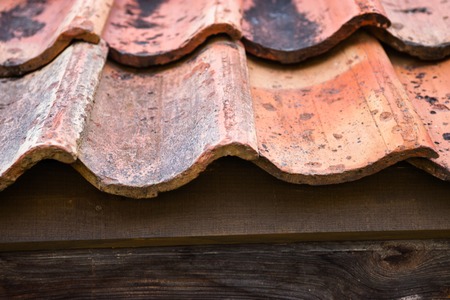 The old roof covered with orange tiles. Close up.