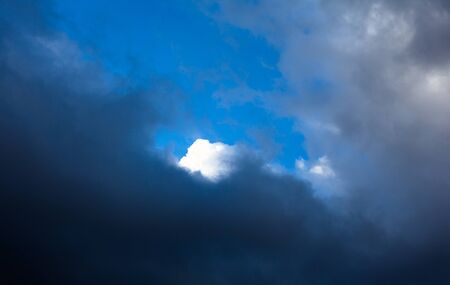 Cloudscape. White cloud behind the gray clouds.