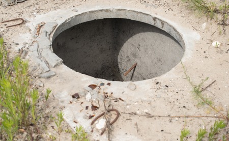 Manhole without cover in the concrete block.の写真素材