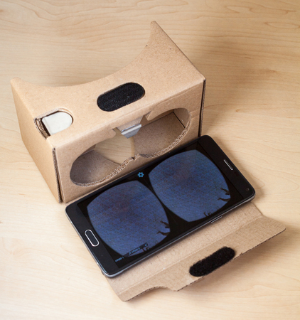 Virtual reality (VR) cardboard headset with smartphone on the table. VR glasses.の写真素材