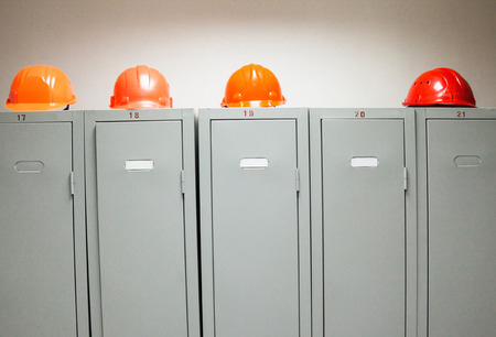 Metal lockers and plastic hard hats in the cloakroom of the industrial plant.の写真素材