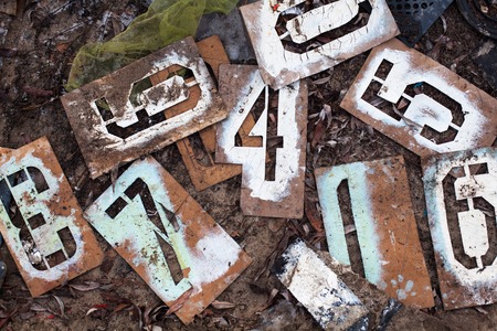 Old metal stencils with different figures on the ground.