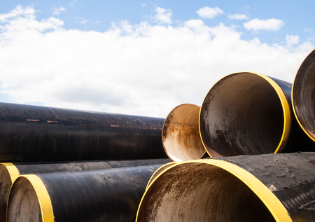 Stack of new metal pipes with yellow-painted edges. Industrial material.の写真素材