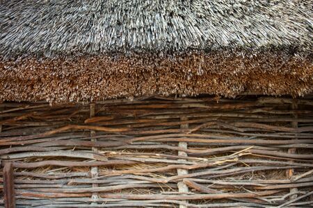 Wattle wall of the shed with straw-thatched roof. Old traditional Ukrainian architecture.の写真素材
