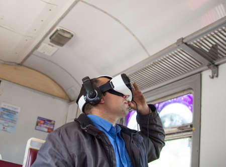 Kyiv Region, Ukraine - October 15, 2015: Passenger in a train watching virtual reality video in VR headset.のeditorial素材