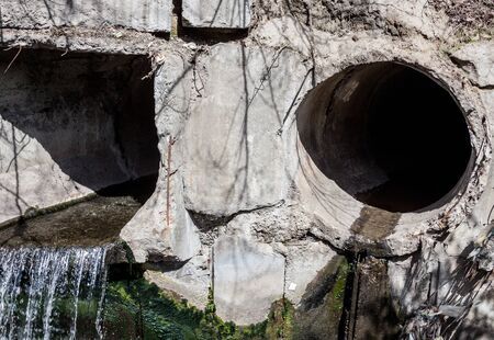 Two large concrete run-off pipes discharging water