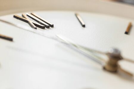 Clock face of the old wall clock. Roman numerals. Hour and minute hands. Time concept. Close-up.の写真素材