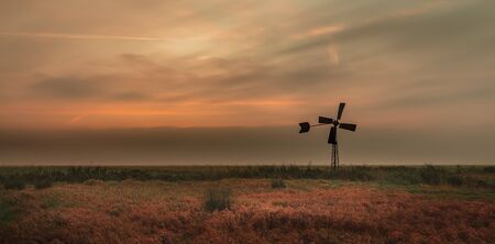 Mill in the field with cloudy skyの写真素材