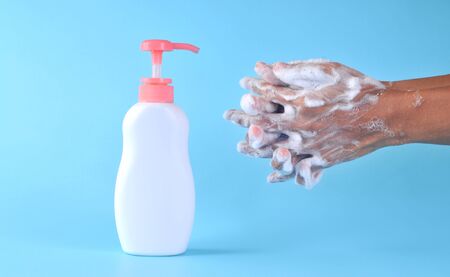 Washing hands with soap on blue background. Closeup of person washing hands. Cleaning Hands....