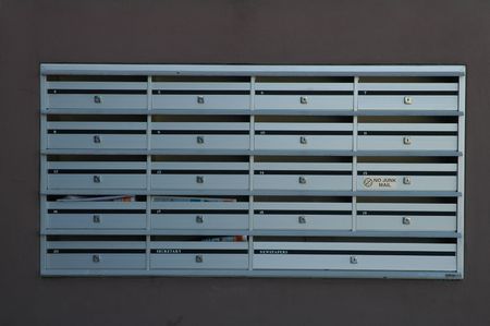 19 steel post boxes, grey wall in background, no junk mail written on itの写真素材